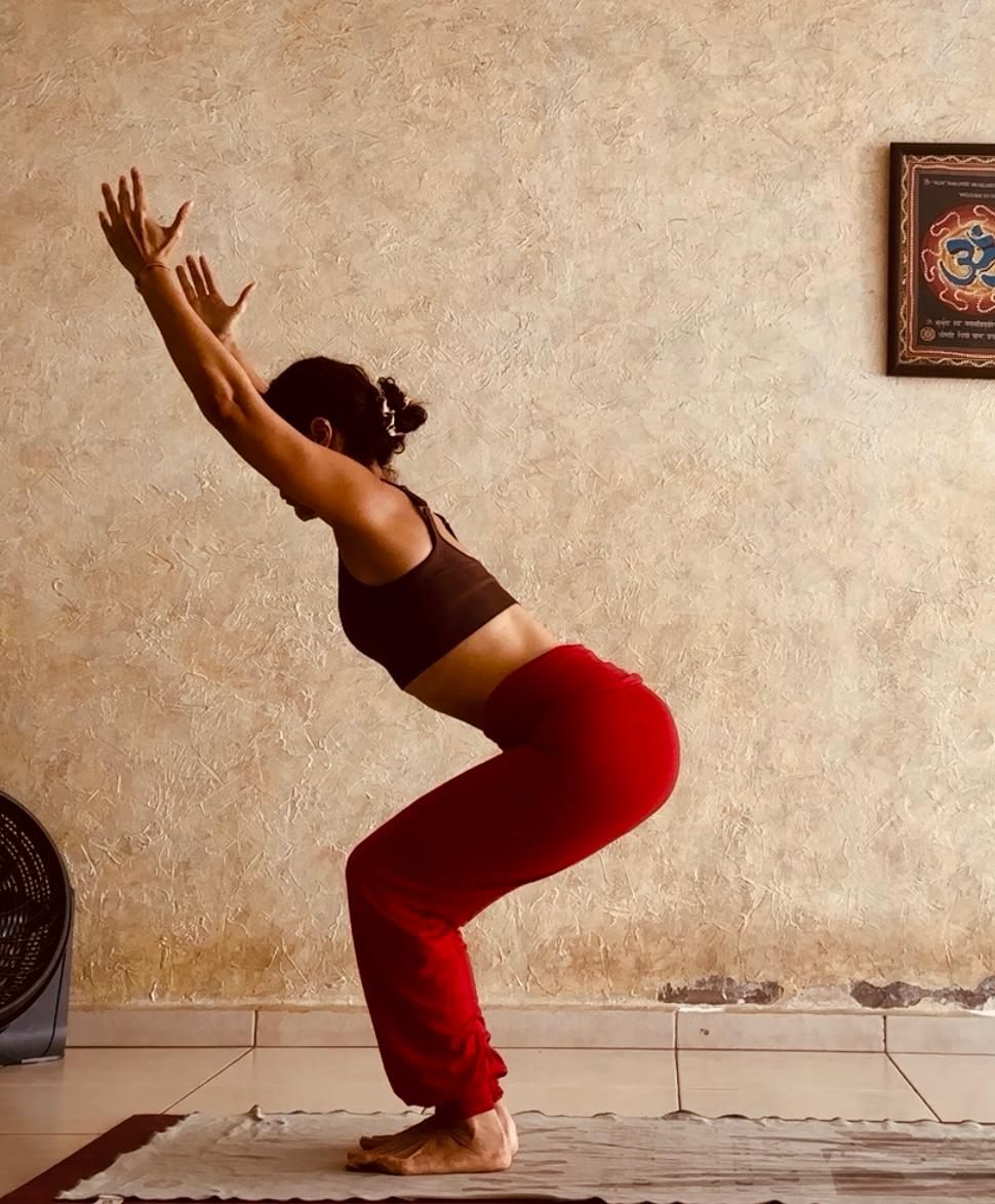 Leticia Mijares en postura de la silla (Utkatasana) con los brazos arriba
